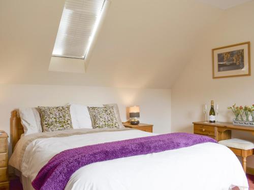 KepcullochThe Stables - Uk5532的一间卧室配有一张带紫色毯子的床