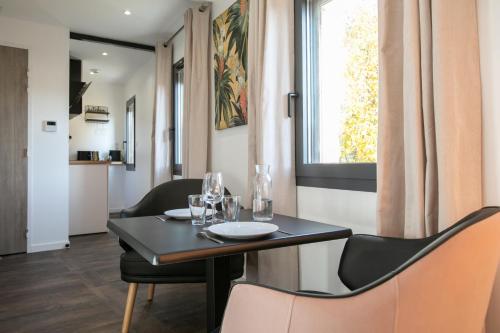 佩里格Le Maleville - Balnéo & Ascenseur的一间带桌椅和窗户的用餐室