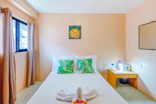长滩岛White Shamrock Beach Hotel的卧室配有白色的床和窗户。