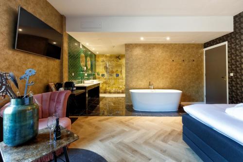 诺格卡斯滕酒店的带浴缸的浴室和1间带1张床的卧室