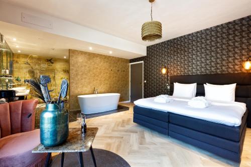 诺格卡斯滕酒店的一间卧室设有一张大床和一个浴缸