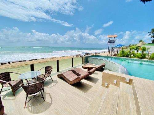 嘎林海斯港Pousada Maracabana Spa的一个带桌椅的游泳池和海滩