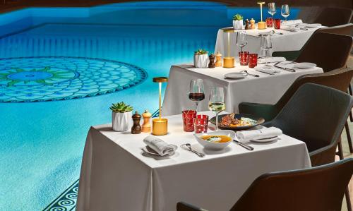 戛纳雄伟戛纳巴里耶尔酒店的一张桌子,上面有白色的桌子,上面有食物和葡萄酒