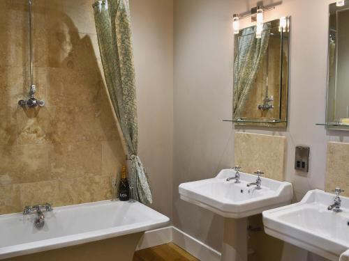RavensworthMill Cottage的浴室设有2个水槽和镜子