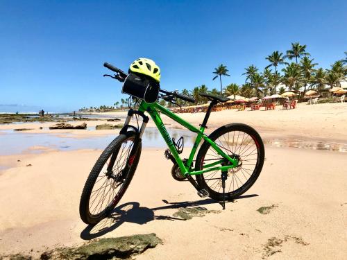 萨尔瓦多TURISHOUSE SUITES的一辆自行车停在海滩上,上面有头盔