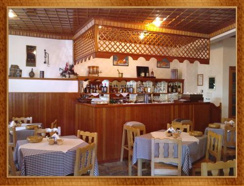 美特索文HOTEL MARI Metsovo的一间设有两张桌子的用餐室和一间酒吧