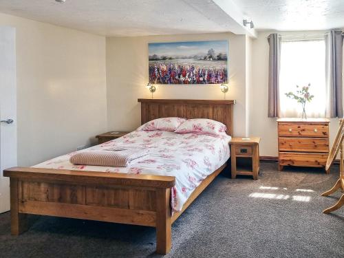 斯泰兹卡布特恩斯乡村别墅的卧室配有一张床,墙上挂有绘画作品