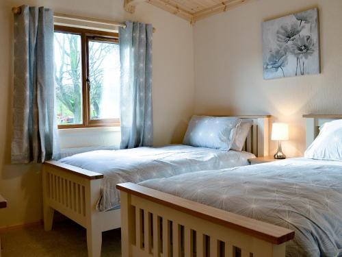 MeadowtownCallow Lodge的一间卧室设有两张单人床和一个窗户。