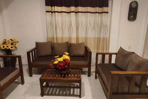 康提Sobasee Holiday Bungalow的客厅配有沙发和鲜花桌