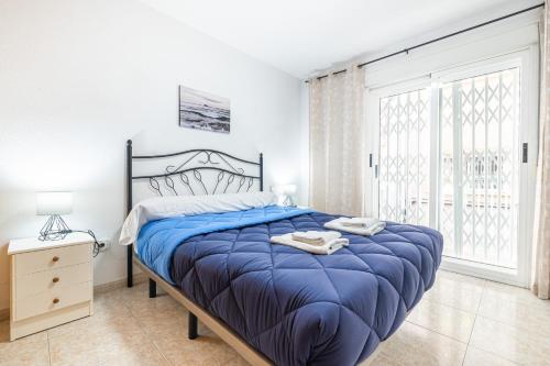 贝尼多姆Benidorm Old Town House - Casa Casco Antiguo的一间卧室配有一张带蓝色棉被的大床