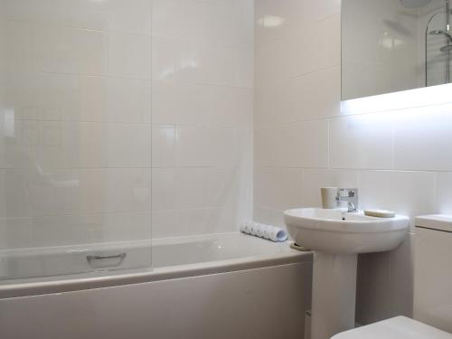 凯西克15 Elm Court的白色的浴室设有水槽和浴缸。