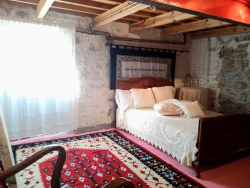 AmpelochórionAlexadras Guesthouse的一间卧室配有一张床和红色地毯