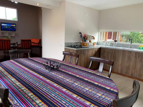 MacasMY HOUSE IN MACAS的厨房里设有一张桌子,上面有五颜六色的地毯