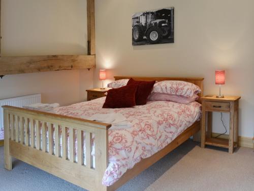 阿德敏斯特老作坊度假屋的一间卧室配有一张带2个床头柜和2盏灯的床。