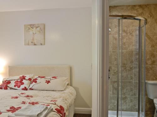 SwimbridgeMole的一间卧室设有一张床和一个玻璃淋浴间