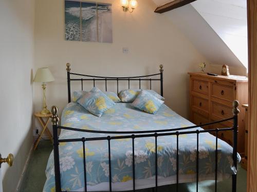 BemptonRockville Cottage - 24376的一间卧室配有一张带蓝色床单和枕头的床。