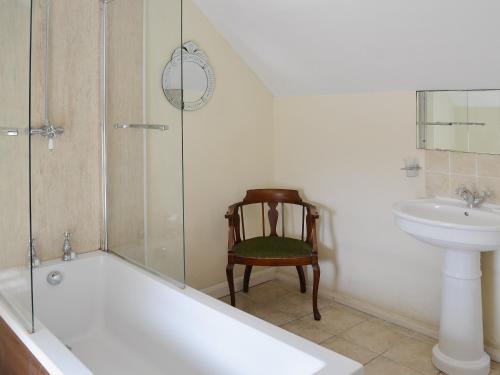 BemptonRockville Cottage - 24376的带浴缸、水槽和椅子的浴室
