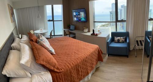 累西腓Flat Beira Mar Boa Viagem- Beach Class Internacional的一间卧室配有一张床、一张书桌和一台电视
