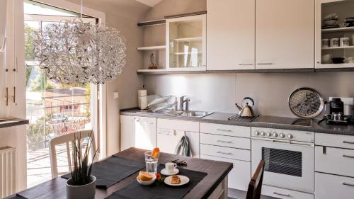 布雷滕Charmante, großzügige Ferienwohnung Villa Fleurie的厨房配有白色橱柜、桌子和水槽。