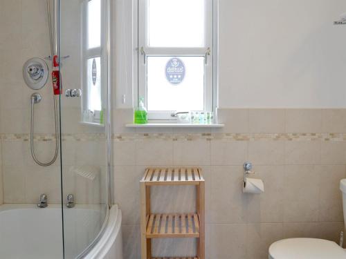 Inchmarlo32 Queens Court的带淋浴和卫生间的浴室以及窗户。