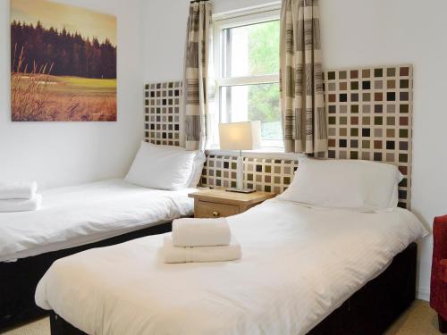 Inchmarlo32 Queens Court的带窗户的客房内设有两张单人床。