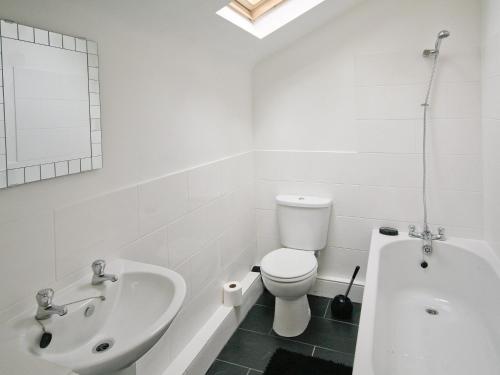 WinthorpeBarn Cottage - E5560的白色的浴室设有水槽、卫生间和浴缸。