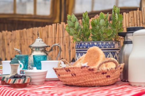 得土安里亚德达里摩洛哥传统庭院住宅的一张桌子,上面放着一篮面包和杯子