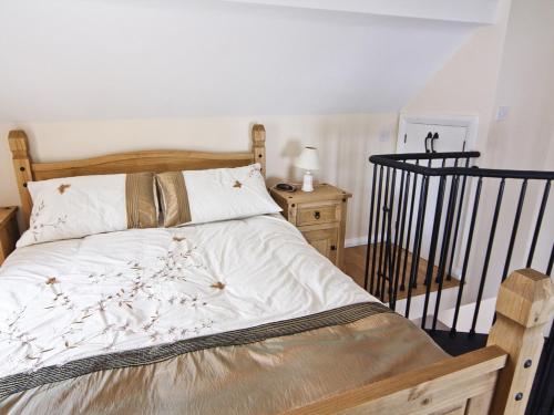 Bettws-yn-RhôsLittle Barn - Hw7615的一间卧室配有一张带白色床单的木床
