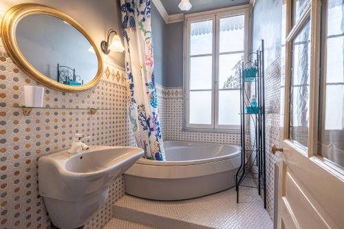 布尔日Le Cedre Bleu的带浴缸、水槽和镜子的浴室