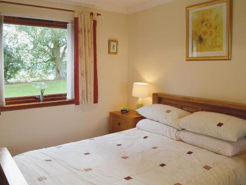 Oakley茵兹瓦尔乡村别墅的一间卧室设有一张床和一个窗口