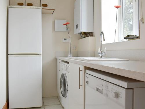 威尔汉姆寇驰乡村别墅的白色的厨房配有水槽和冰箱