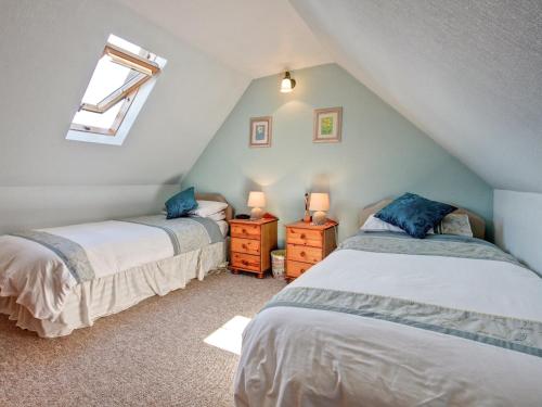 托里登克拉禅乡村别墅的阁楼卧室设有两张床和窗户。
