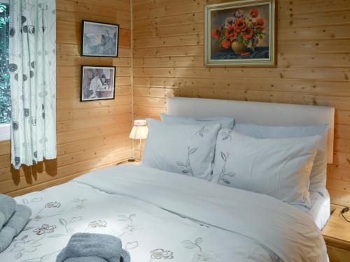 Crackington Haven切特里瓦撒乡村别墅的卧室配有白色的木墙床