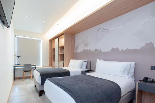 圣地亚哥Almasur Providencia的酒店客房配有两张床和一张书桌