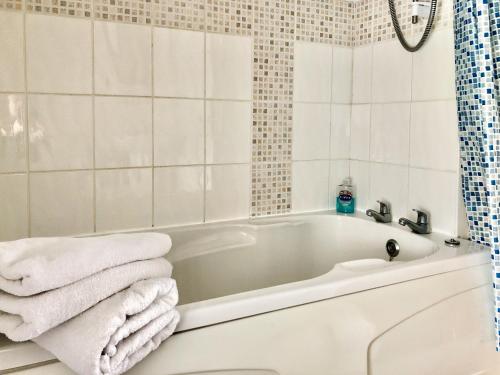 Kniveton奶品乡村别墅的白色的浴室设有浴缸和毛巾