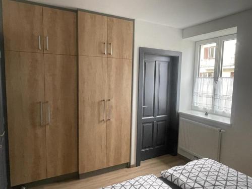 霍恩Apartment Viktoria的一间卧室设有木制橱柜、一张床和一个窗户。