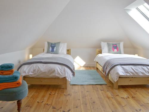 DouslandSouthlake Barn的一间卧室设有两张单人床和一张蓝色椅子