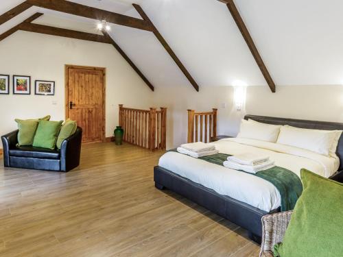 Byers GreenHall Farm Cottage的一间卧室配有一张大床和一把椅子