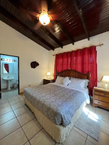 埃尔巴列德安通La Casa de los Patos的一间卧室配有一张带红色窗帘的大床
