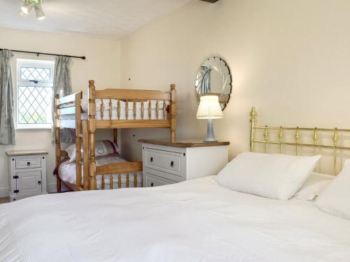 基尔格蒂绿色英亩度假屋的卧室配有白色的床和梳妆台。