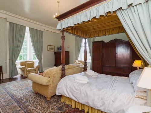 Turriff赛慕碧斯特乡村别墅的一间卧室配有一张大天蓬床和一把椅子