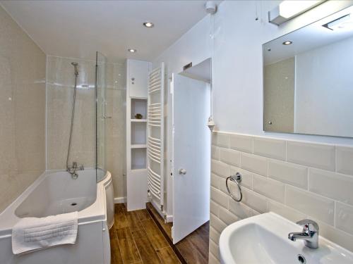 布里克瑟姆Pilgrims Cottage的白色的浴室设有浴缸和水槽。