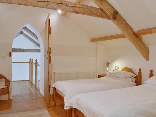 Llanwrda亚斯塔贝尔乡村别墅的白色客房的两张床,设有窗户
