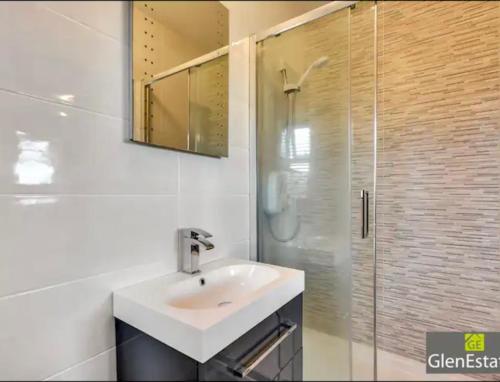 CarrigartBridgeview的白色的浴室设有水槽和淋浴。