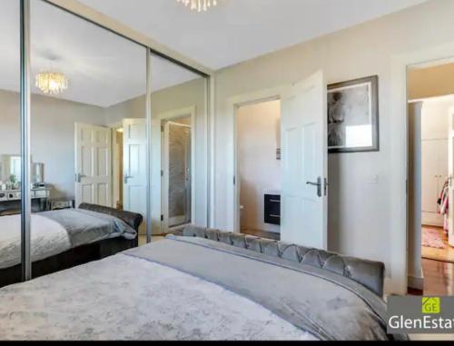 CarrigartBridgeview的一间卧室设有两张床和大镜子