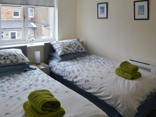 安布尔Kittiwakes的一间卧室配有两张床和绿毛巾。