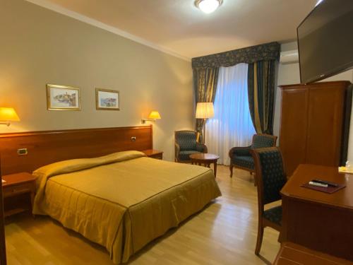 Gattinara埃尔威尼托酒店的酒店客房,配有一张床、一张桌子和椅子