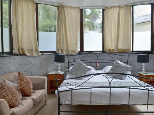Saint CleerRosecraddoc Manor - Stable的一间卧室配有一张床、一张沙发和窗户。
