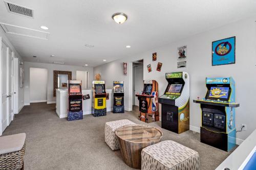 奥兰多Spacious 8 BDR Family Home with Arcades and Free Pool Heat的一间设有数个街机游戏和桌子的房间