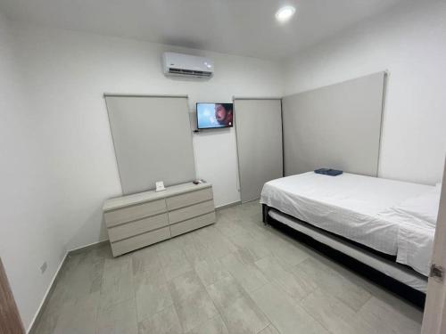 吉拉尔多特Casa Campestre Girardot的卧室配有一张床,墙上配有电视。
